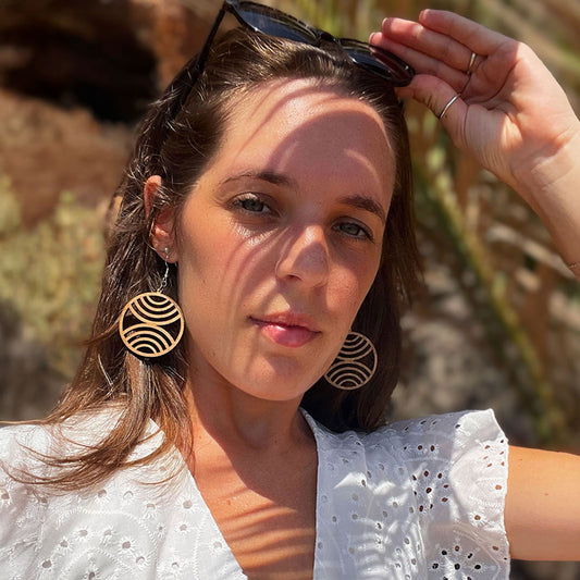 Femme portant les boucles d’oreilles en bois fait-main Cala Egos, création artisanale Paola Mallorca