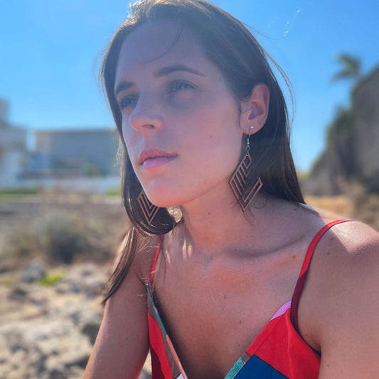 Femme portant des boucles d’oreilles en bois fait-main Cala Es Trenc, création artisanale Paola Mallorca