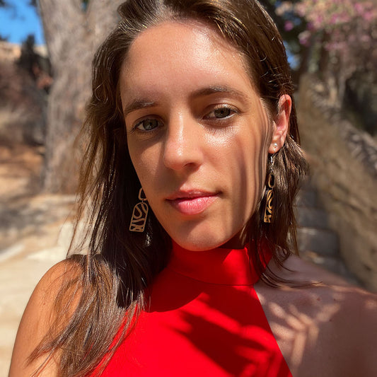 Femme portant les boucles d’oreilles en bois Cala Esmeralda fait-main par Paola Mallorca