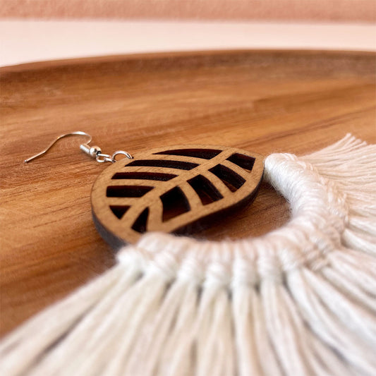 Zoom sur les boucles d’oreilles en bois fait-main avec de la corde macramé blanche