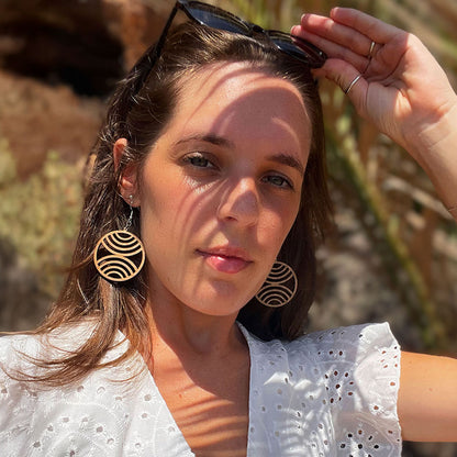 Femme portant les boucles d’oreilles en bois fait-main Cala Egos, création artisanale Paola Mallorca